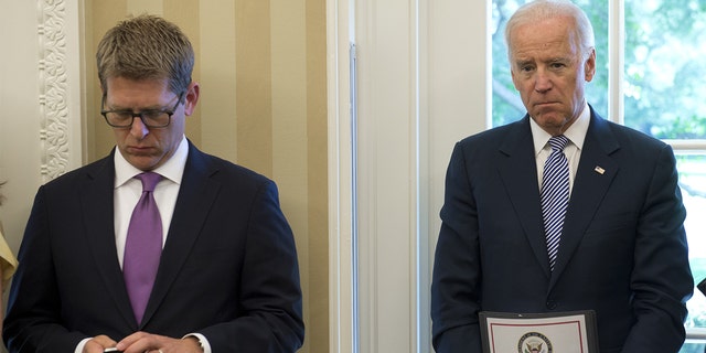 Vice President Joe Biden, right, holds a classified document while standing beside White House press secretary Jay Carney in the Oval Office on Sept. 30, 2013.