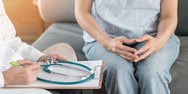 Stock photo shows a doctor sitting with his patient. 