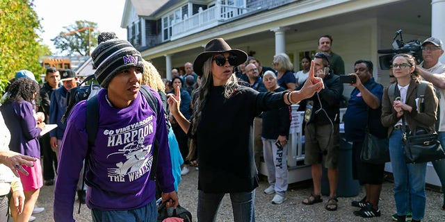 A Venezuelan migrant is led onto a bus at St. Andrews Episcopal Church on Friday, Sept. 16, 2022, in Edgartown, Massachusetts, on the island of Martha's Vineyard. 