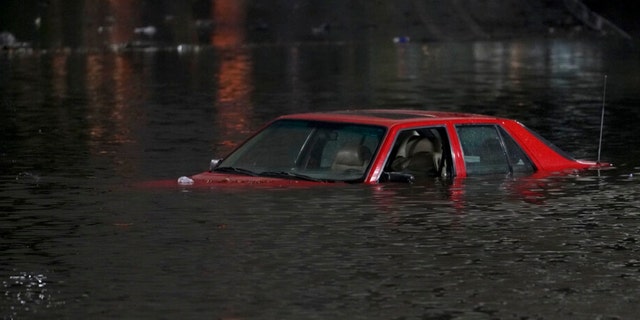 An empty vehicle is surrounded by floodwaters on a road in Oakland, Calif., Wednesday, Jan. 4, 2023.