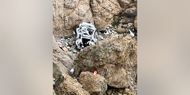 This image from video provided by San Mateo County Sheriff's Office shows a Tesla vehicle that plunged off a Northern California cliff along the Pacific Coast Highway, Monday, Jan. 2, 2023, near an area known as Devil's Slide, leaving four people in critical condition, a fire official said. 