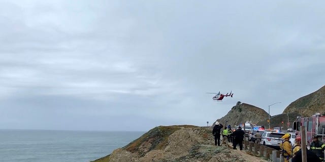 This image from video provided by Cal Fire San Mateo, Santa Cruz Unit, emergency personnel respond to the scene after a Tesla plunged off a cliff along the Pacific Coast Highway, Monday, Jan. 2, 2023, in Northern California. 