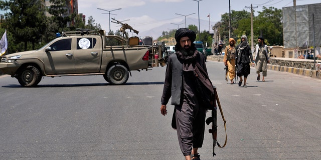 Taliban fighters guard the site of an explosion in Kabul, Afghanistan.