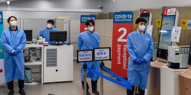 Quarantine officials seen preparing for a PCR test for travelers arriving from China in COVID-19 testing station at Incheon International Airport, west of Seoul.