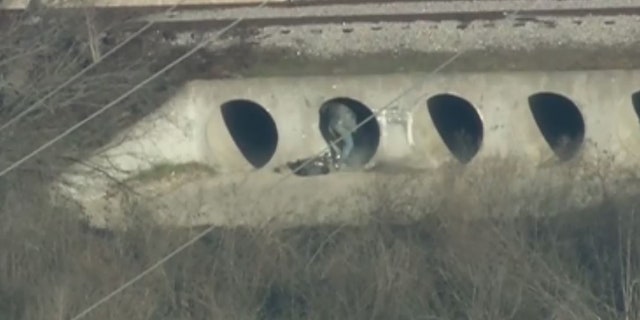 A police robot launched smoke bombs into the culvert to force the suspect into the open.