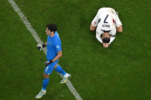 Portugal's Cristiano Ronaldo sinks to the ground beside Moroccan goalkeeper Yassine Bounou.