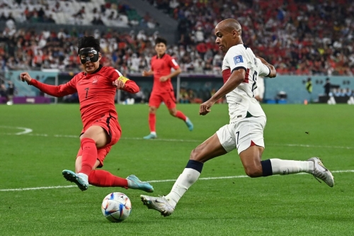 South Korea's Son Heung-min slides for a tackle against Portugal's João Mário. Portugal lost the match but still won Group H.