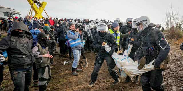 Police officers carry a demonstrator at the village Luetzerath near Erkelenz, Germany, on Jan. 10, 2023. The village of Luetzerath is occupied by climate activists fighting against the demolition of the village to expand a coal mine near the Dutch border.