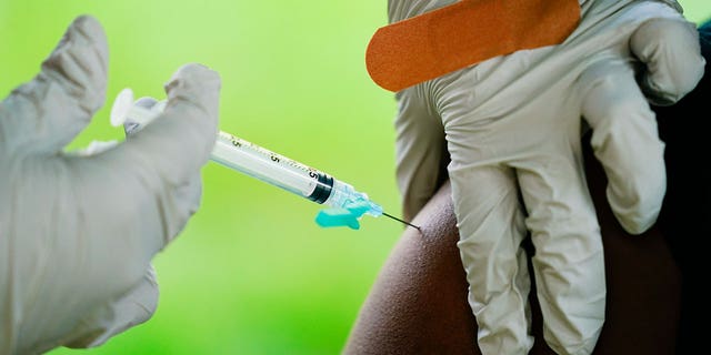 FILE - A health worker administers a dose of COVID-19 vaccine during a vaccination clinic in Reading, Pa. COVID-19 vaccinations are at a critical juncture as companies test whether new approaches like combination shots or nasal drops can keep up with a mutating coronavirus — even though it’s not clear if any change is needed. (AP Photo/Matt Rourke, File)