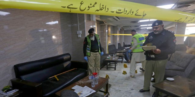 Police officers examine the crime scene following a shooting incident on the premises of the Peshawar High Court in Peshawar, Pakistan, on Jan. 16, 2023.