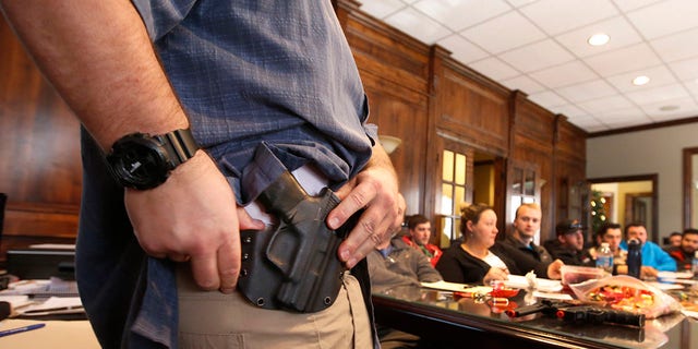 Damon Thueson shows a holster at a gun concealed carry permit class put on by USA Firearms Training on Dec. 19, 2015, in Provo, Utah.