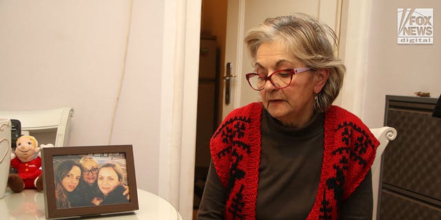 Milanka Ljubicic looks at a photo of her daughters, Ana and Aleksandra in her apartment in Belgrade, Serbia on Monday, January 9, 2023. Ljubicic's daughter, Ana Walshe is missing from her Cohasset, Massachusetts home, last seen on New Year's Day.