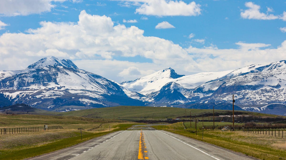 A road stretches off into the distance. Mountains on the horizon.