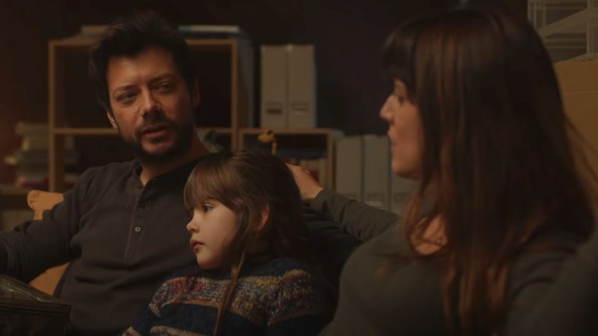 A father, mother and daughter sitting on the couch