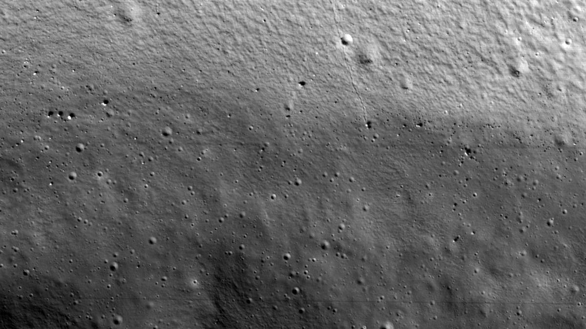 Black and white view into Shackleton crater on the moon reveals boulders and pockmarks.