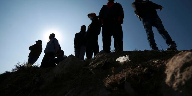 Migrants stand near the U.S.-Mexico border in Ciudad Juarez, Mexico, Dec. 19, 2022. 