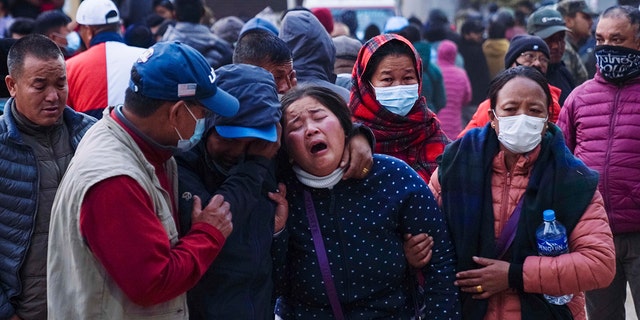 A woman cries as the body of a relative, victim of a plane crash, is brought to a hospital in Pokhara, Nepal, Sunday, Jan. 15, 2023.