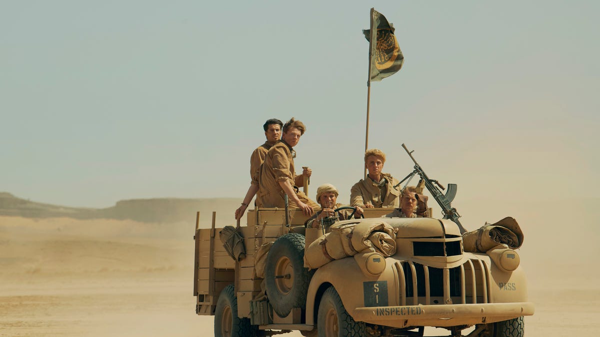 An open-top truck carrying soldiers in the desert in WW2 TV series Rogue Heroes.