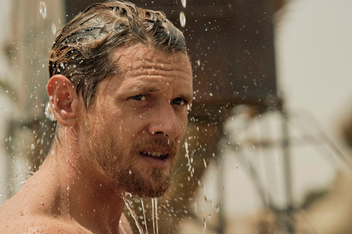 Bearded Jack O'Connell smolders under a shower in TV show Rogue Heroes.