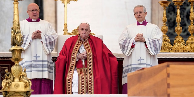 Pope Francis sits by the coffin of late Pope Emeritus Benedict XVI St. Peter's Square during a funeral mass at the Vatican, Thursday, Jan. 5, 2023. 