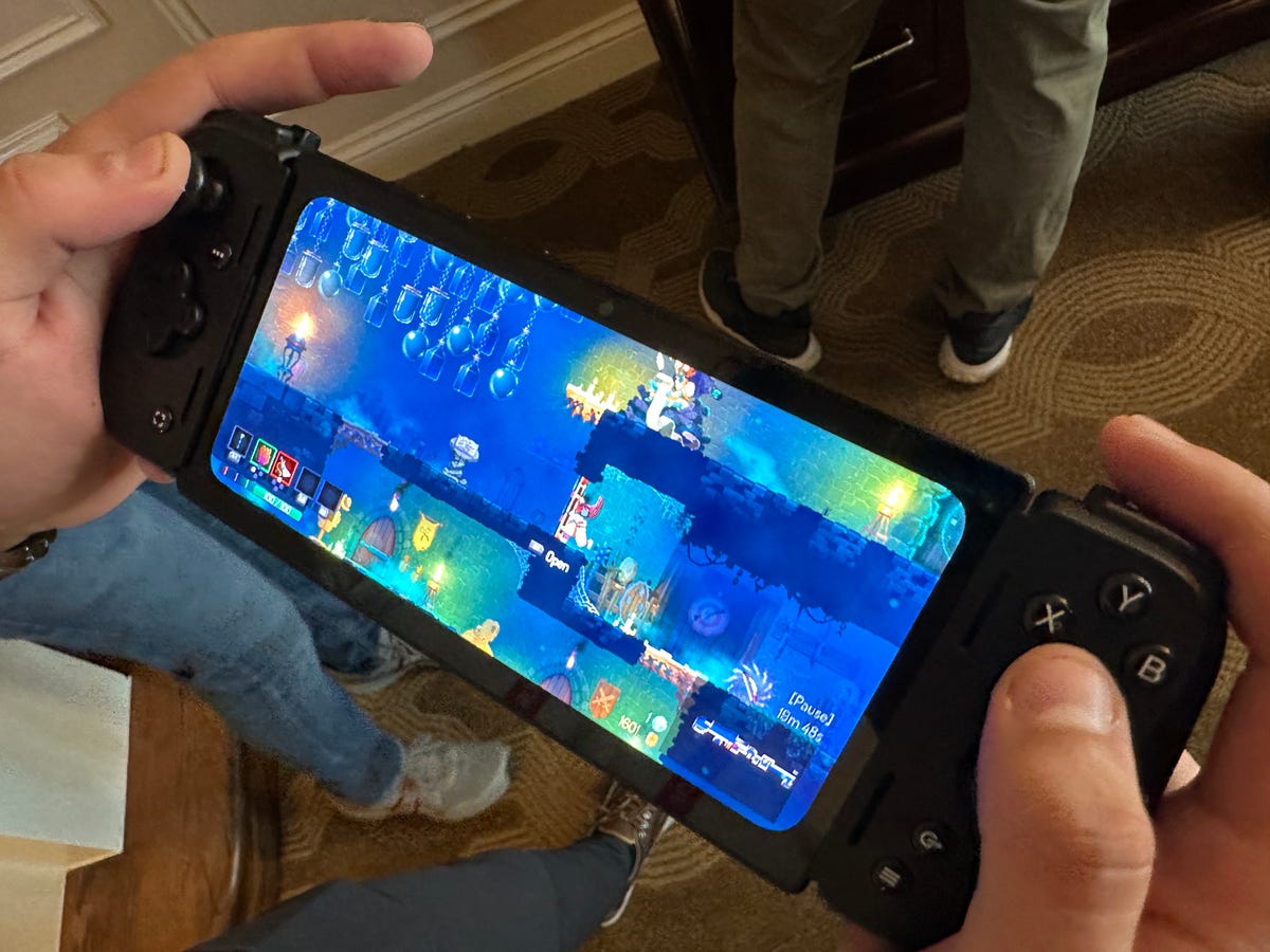 Razer Edge game handheld, held in someone's hands in a room