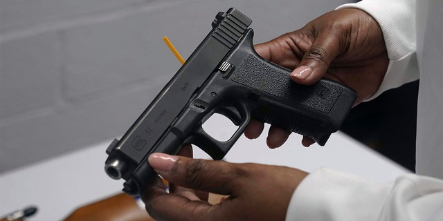 A handgun is inspected during a gun buyback event in Brooklyn, New York City, May 22, 2021.