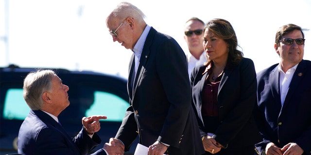 President Biden shakes hands with Texas Gov. Greg Abbott after Abbott handed him a letter about the border at El Paso International Airport in El Paso, Texas.