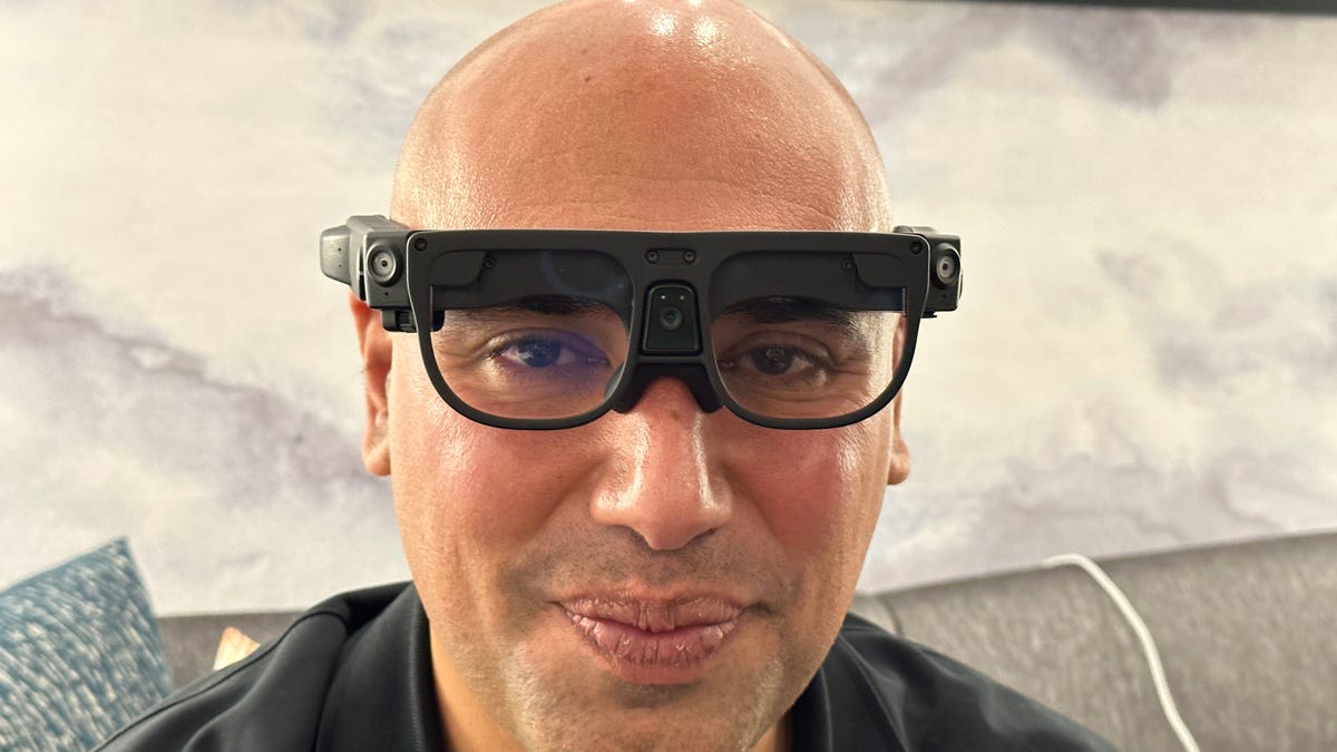 Bald man wearing a large pair of black smartglasses