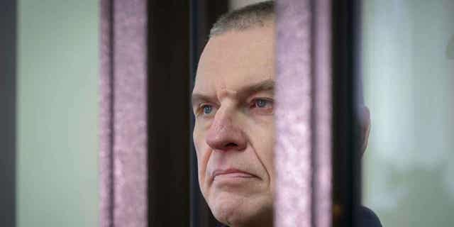 Journalist Andrzej Poczobut stands in a defendant's cage during a court session in Grodno, Belarus, on Jan. 16, 2023. The trial for the journalist in Belarus who is facing charges of inciting discord and harming national security opened.