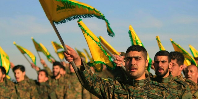 Hezbollah fighters hold flags as they attend the memorial of their slain leader Sheik Abbas al-Mousawi, who was killed by an Israeli airstrike in 1992, in Tefahta village, south Lebanon. A United Nations official drawn scorn from Israeli diplomats for thanking one of the terror group's top leaders following a meeting. 