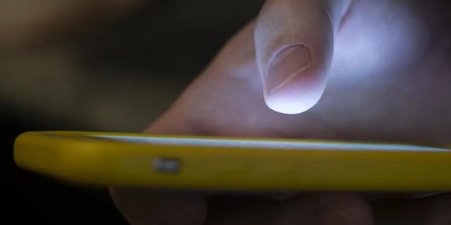 A man uses a cell phone in New Orleans, Aug. 11, 2019. The 988 mental health and suicide helpline has quickly expanded its reach in the six months since it launched. It has received just over 2 million calls, texts and chat message since July. 