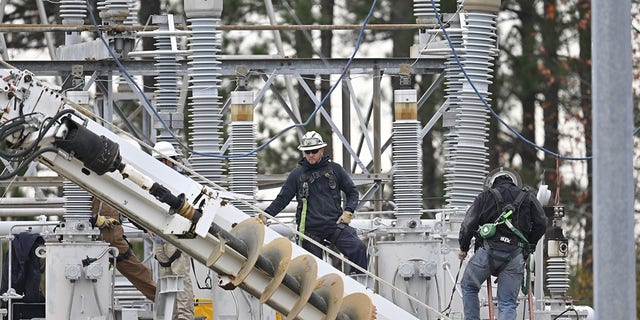 Work to restore power is in progress on Dec. 5, 2022, in Moore County, North Carolina, after two substations operated be Duke Electric were shot at in Carthage.