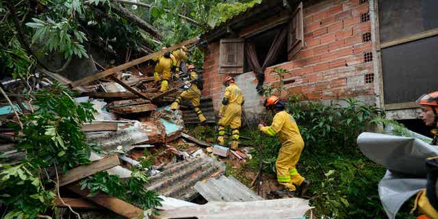 Rescue workers search for survivors after flooding caused landslides near a beach in Sao Sebastiao, Brazil, on Feb. 20, 2023. 