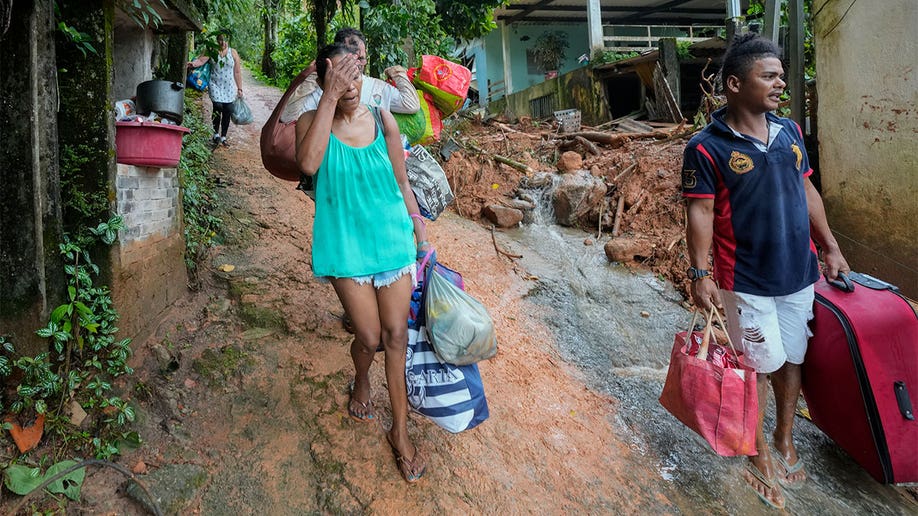 Residents walking down the road with their luggage.