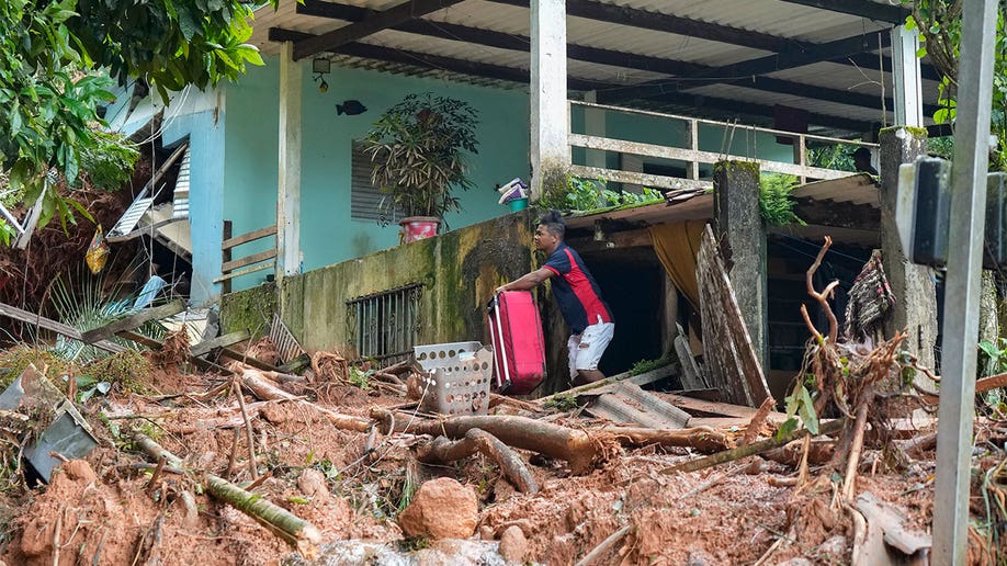 A man carrying his luggage after being forced out of his from from the destruction.