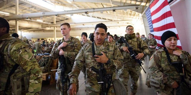 Soldiers with the 82nd Airborne division listen to instructions before deploying to Poland on Feb. 14, 2022 at Fort Bragg, Fayetteville, North Carolina ahead of Russia's invasion of Ukraine.