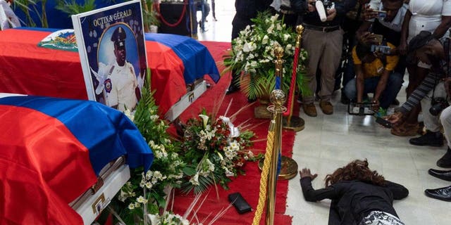 A woman cries near the coffins during the funeral of three police officers at the National Police School in Port-au-Prince, Haiti, on January 31, 2023.