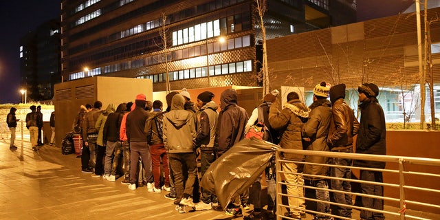 Migrants queue for food at a bus station in front of the Tiburtina railway station in Rome March 8, 2017.