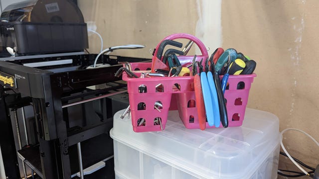 A pink hand basket full of tools