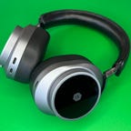 Master & Dynamic MW75 headphones on green background
