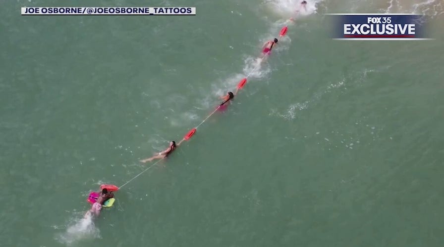 Florida lifeguards form human chain to rescue boogie boarder