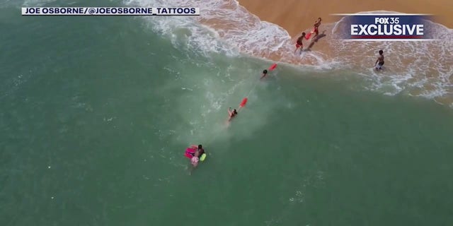 lifeguards and boogie boarder reaching shore