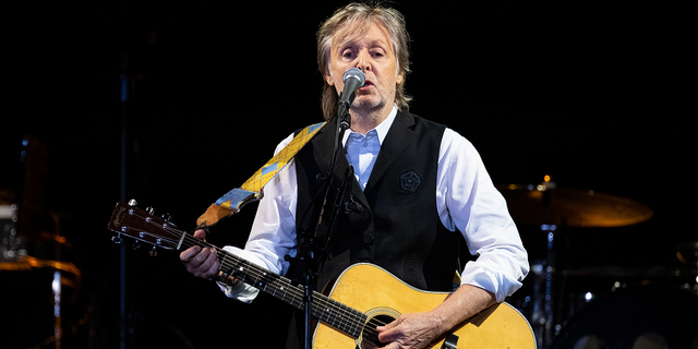 Paul McCartney performs with guitar