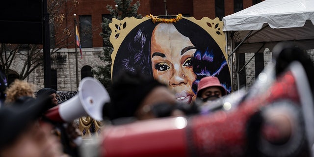 Breonna Taylor poster behind crowd of protesters