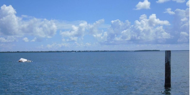 George Pino's capsized boat near a channel marker in the water