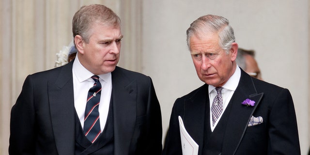 Prince Andrew and King Charles wearing matching dark suits looking serious