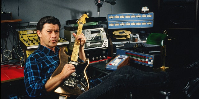 Robbie Robertson holds guitar in recording studio