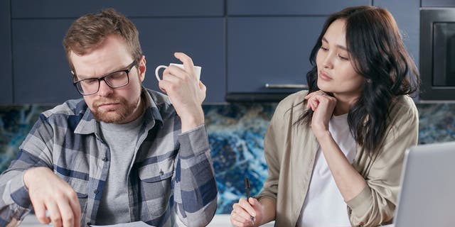 Photo of a husband and wife looking up their insurance company.