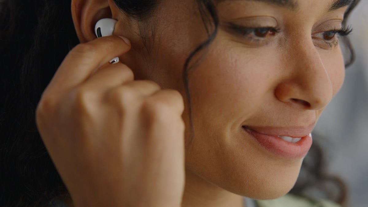 A woman using her fingers to swipe on a pair of AirPods Pro