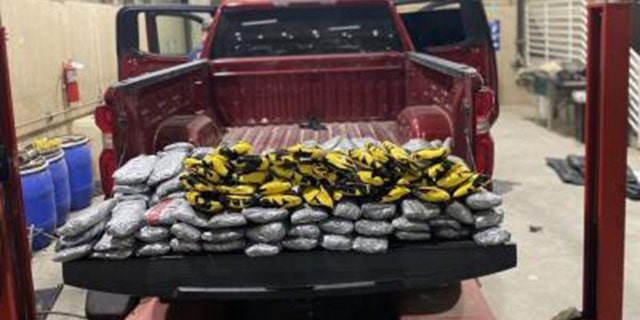 Red truck shown with packages of narcotics